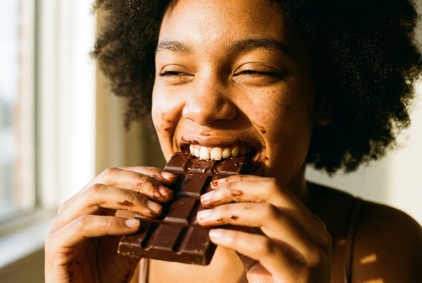 Someone taking a big, satisfying bite of NÄKT chocolate Someone taking a big, satisfying bite of NÄKT chocolate