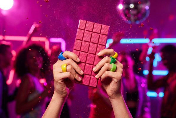 Pink RAVE bar held up against a neon background Pink RAVE bar held up against a neon background